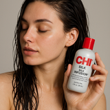 Woman with wet hair applying CHI Silk Infusion hair treatment for smooth, frizz-free shine – paraben-free hair serum.